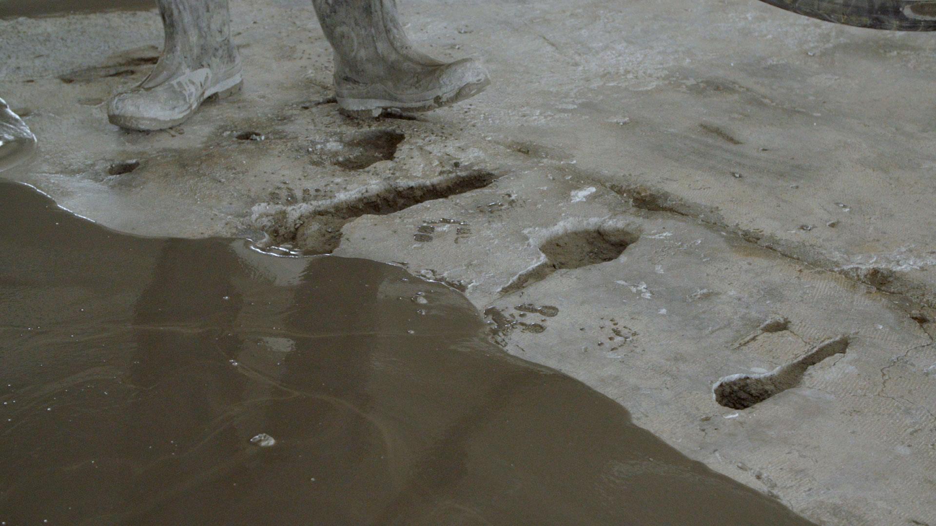 Industriële vloer met gaten en oneffenheden die gerepareerd wordt door middel van een egalisatie middel.